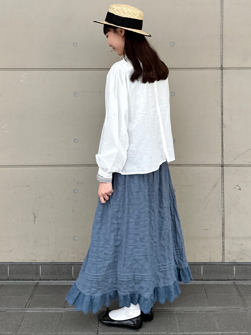 ホワイト系のシャツ/ブラウス、グレー系のTシャツ/カットソー、ブルー系のスカートを着用したレディースの春コーディネートの2枚目の写真