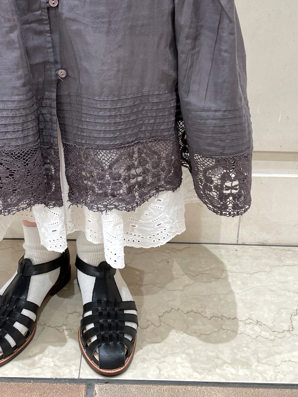 グレー系のワンピース、ブラック系のトートバッグ、ブラック系のサンダルを着用したレディースの夏コーディネートの3枚目の写真