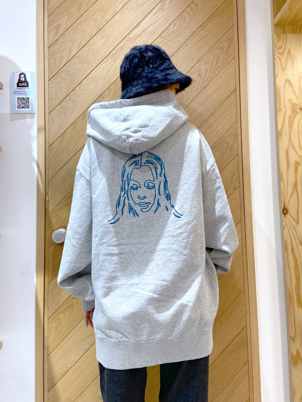 ブラック系のデニムパンツ、グレー系のパーカー、ブラック系のショルダーバッグを着用したレディースの秋コーディネートの2枚目の写真