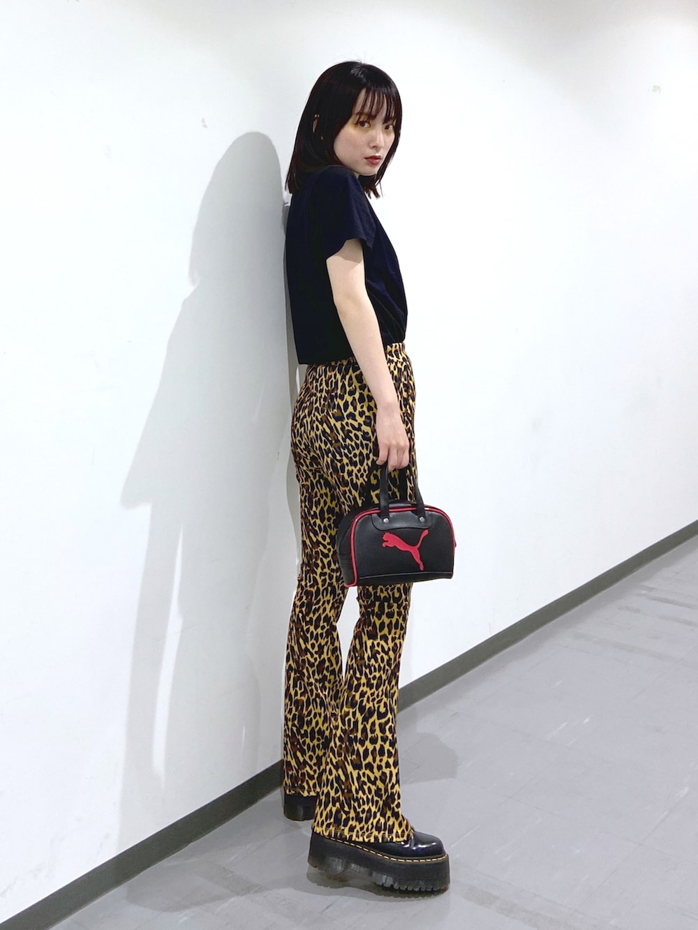 ブラック系のTシャツ/カットソー、ベージュ系のその他パンツ、ブラック系のブーツを着用したレディースの春コーディネートの2枚目の写真