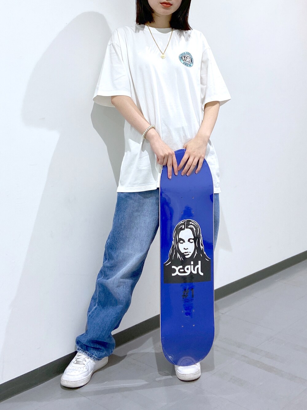ホワイト系のスニーカー、ホワイト系のTシャツ/カットソー、ブルー系のデニムパンツを着用したレディースの春コーディネートの2枚目の写真