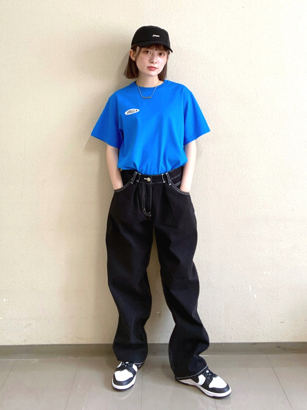 ブルー系のTシャツ/カットソー、ブラック系のデニムパンツ、ブラック系のキャップを着用したレディースの夏コーディネートの2枚目の写真