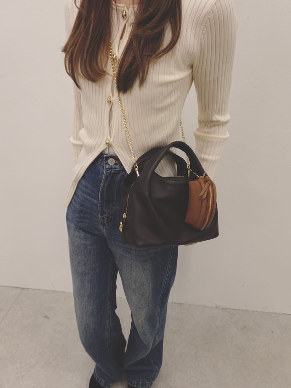 ブラウン系のショルダーバッグ、イエロー系のその他小物を着用したレディースの冬コーディネートの2枚目の写真