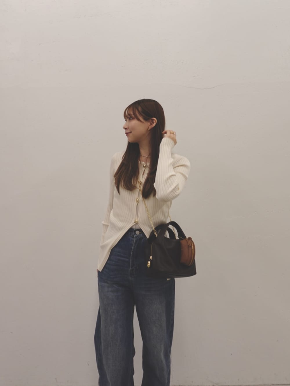 ブラウン系のショルダーバッグ、イエロー系のその他小物を着用したレディースの冬コーディネートの3枚目の写真