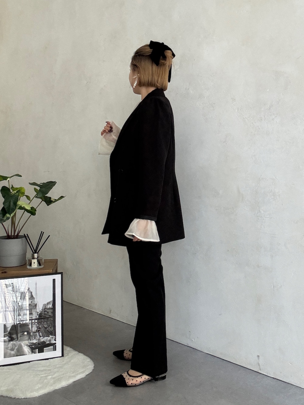 ブラック系のテーラードジャケット、ホワイト系のパンツドレス、ブラック系のショルダーバッグを着用したレディースの冬コーディネートの2枚目の写真