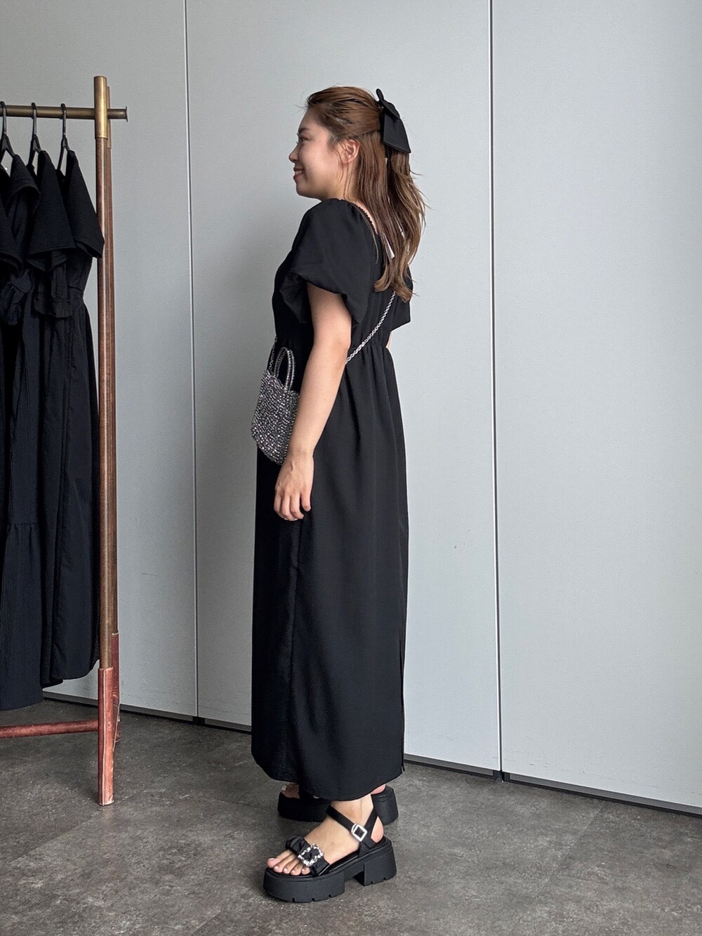 ブラック系のワンピース、ブラック系のサンダルを着用したレディースの夏コーディネートの2枚目の写真