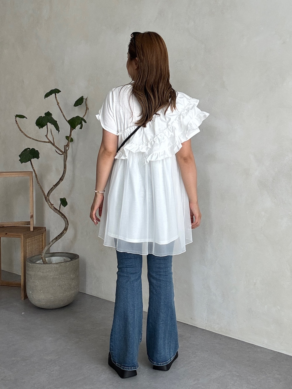 ホワイト系のTシャツ/カットソー、ブラック系のショルダーバッグ、ブルー系のデニムパンツを着用したレディースの夏コーディネートの3枚目の写真