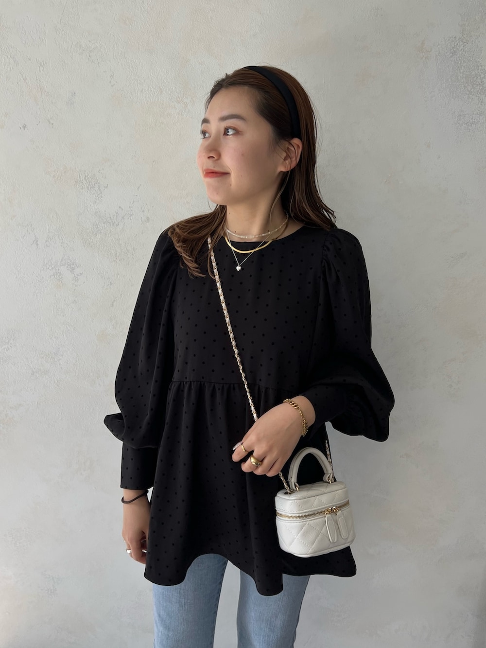 ブラック系のシャツ/ブラウス、ブラック系のショルダーバッグ、ブルー系のデニムパンツを着用したレディースの夏コーディネートの2枚目の写真