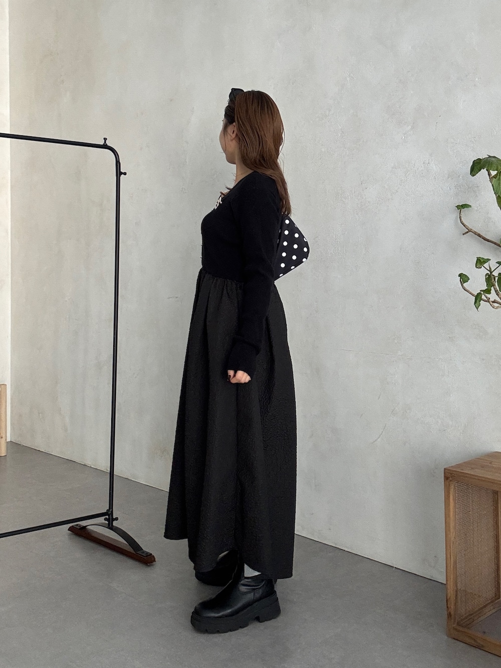 ブラック系のワンピース、ブラック系のブーツを着用したレディースの秋コーディネートの2枚目の写真