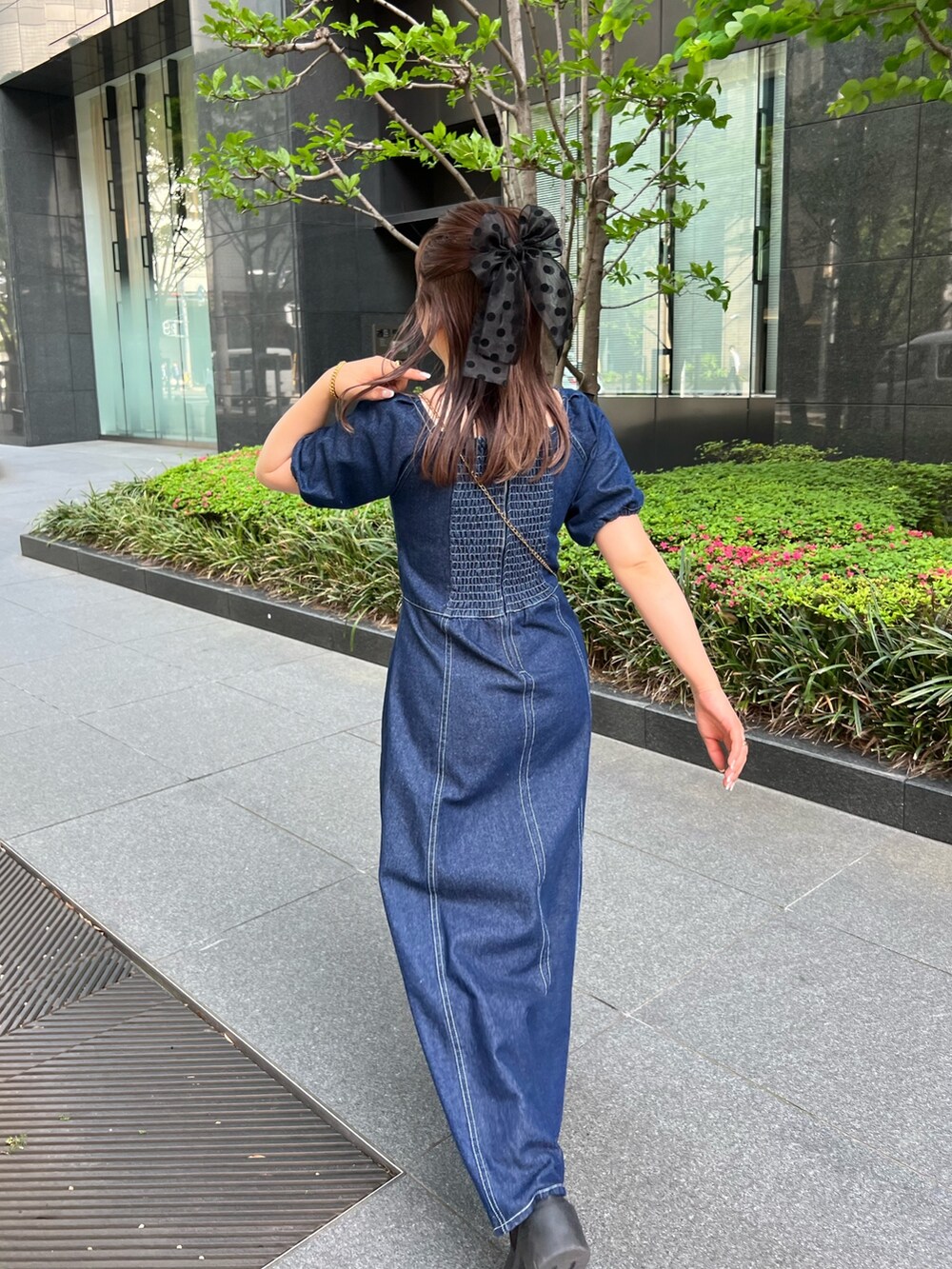 ブルー系のワンピース、ベージュ系のショルダーバッグ、ブラック系のヘアゴムを着用したレディースの春コーディネートの2枚目の写真