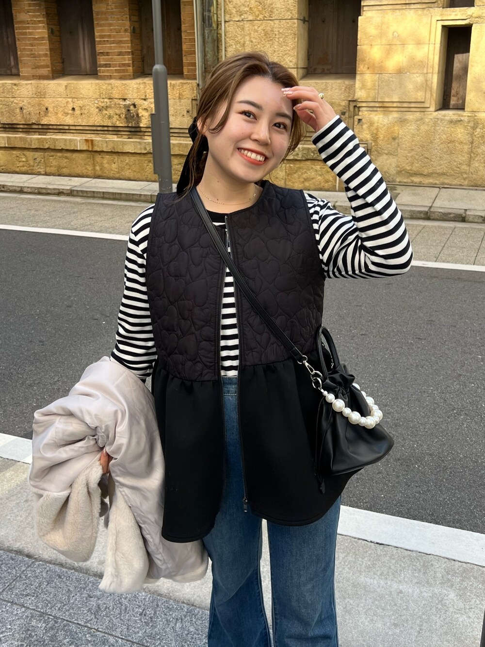 ブラック系のTシャツ/カットソー、ブラック系のジャケット/アウター、ブラック系のショルダーバッグを着用したレディースの冬コーディネートの2枚目の写真