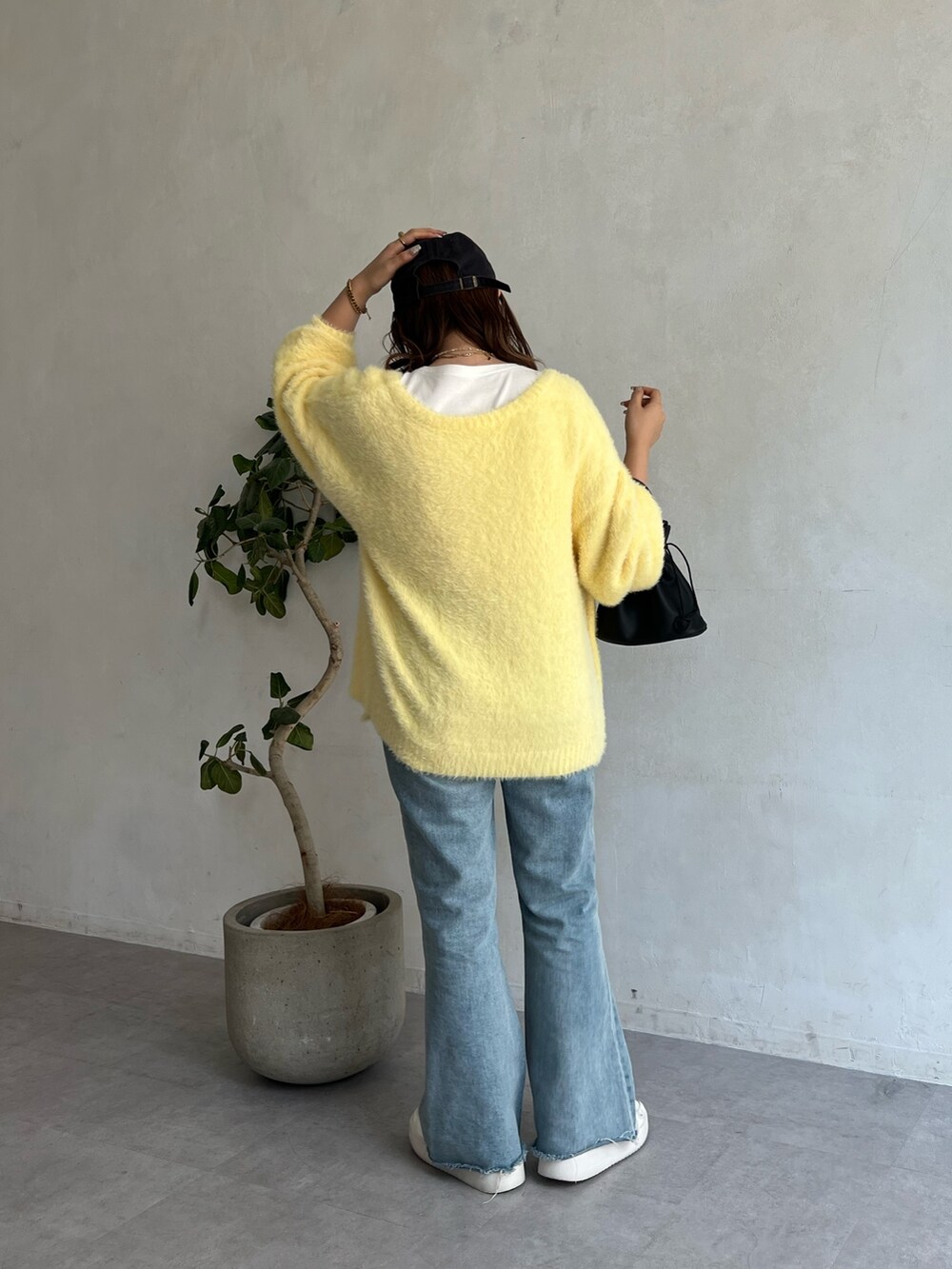 イエロー系のカーディガン/ボレロ、ホワイト系のTシャツ/カットソー、ブルー系のデニムパンツを着用したレディースの夏コーディネートの2枚目の写真