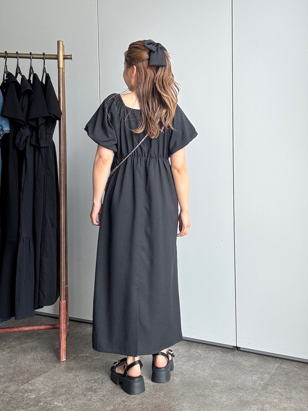 ブラック系のワンピース、ブラック系のサンダルを着用したレディースの夏コーディネートの3枚目の写真