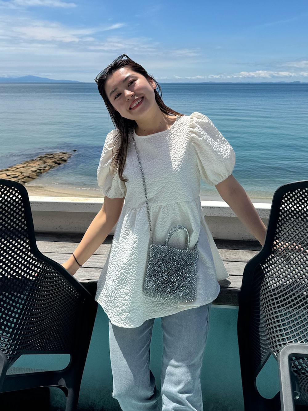 ホワイト系のシャツ/ブラウス、ブルー系のデニムパンツを着用したレディースの夏コーディネートの3枚目の写真