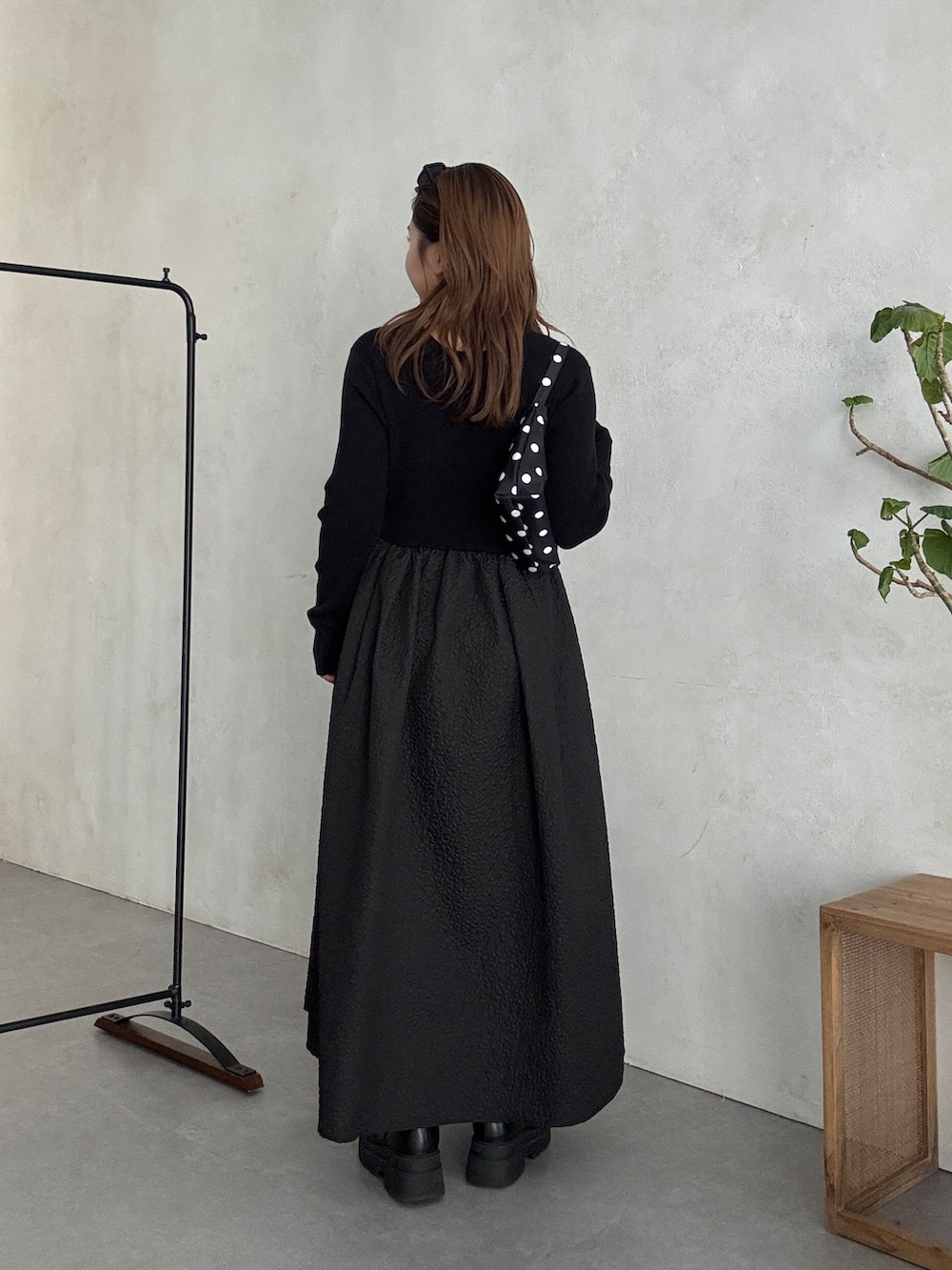 ブラック系のワンピース、ブラック系のブーツを着用したレディースの秋コーディネートの3枚目の写真