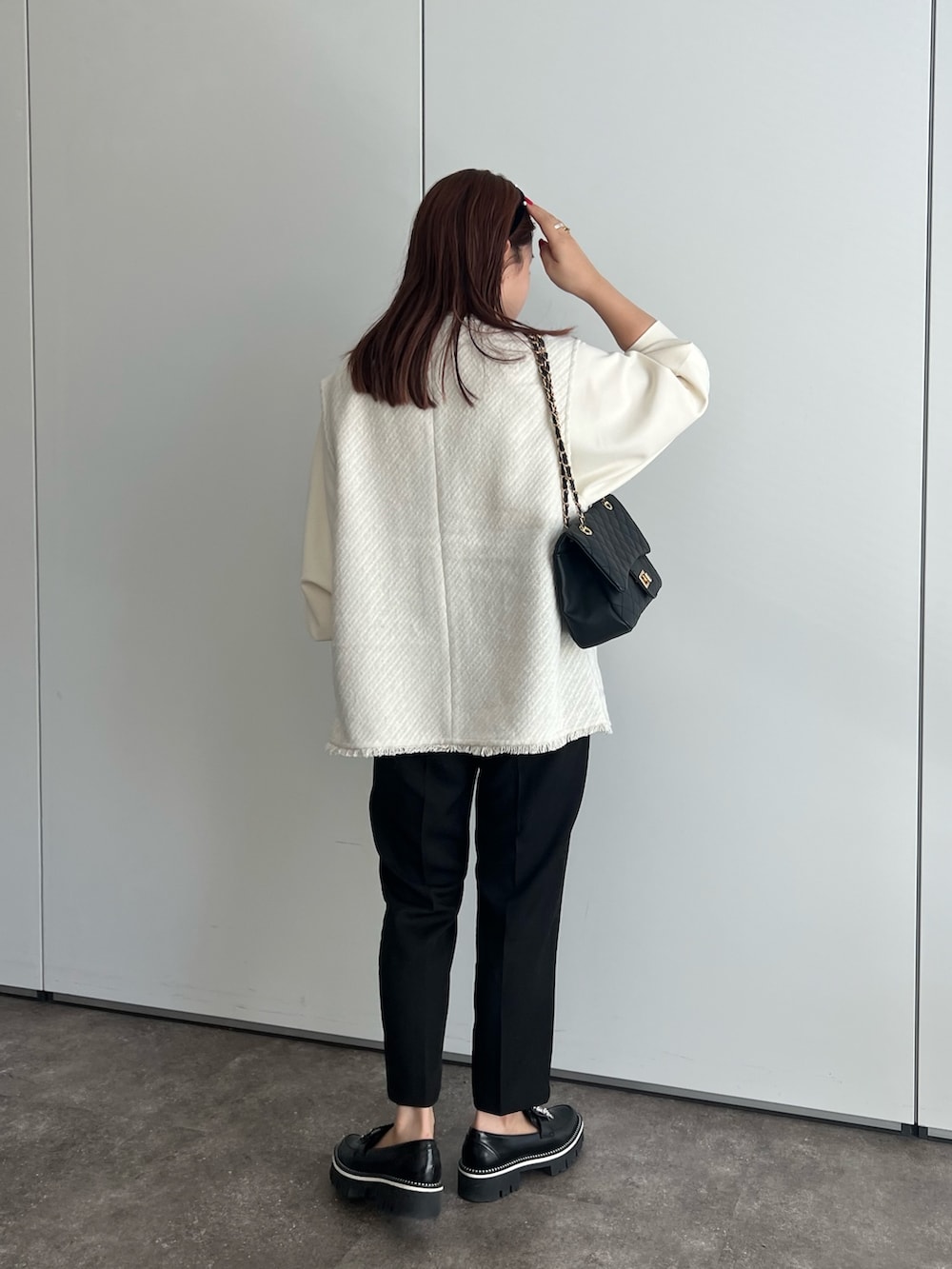 ホワイト系のベスト、ホワイト系のTシャツ/カットソー、ホワイト系のショルダーバッグを着用したレディースの夏コーディネートの2枚目の写真