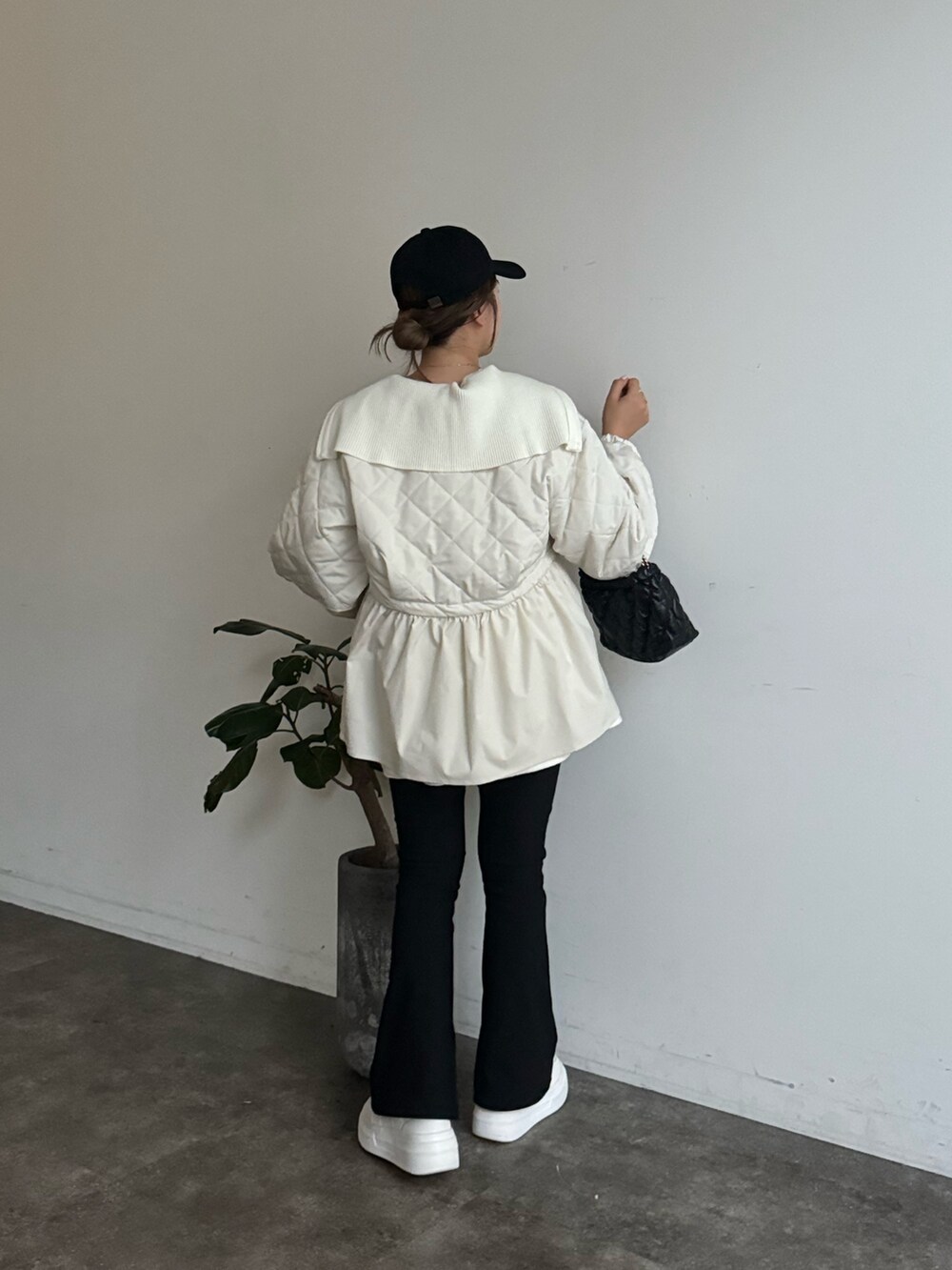 ブラック系のブルゾン、ブラック系のニット/セーター、ホワイト系のTシャツ/カットソーを着用したレディースの冬コーディネートの3枚目の写真