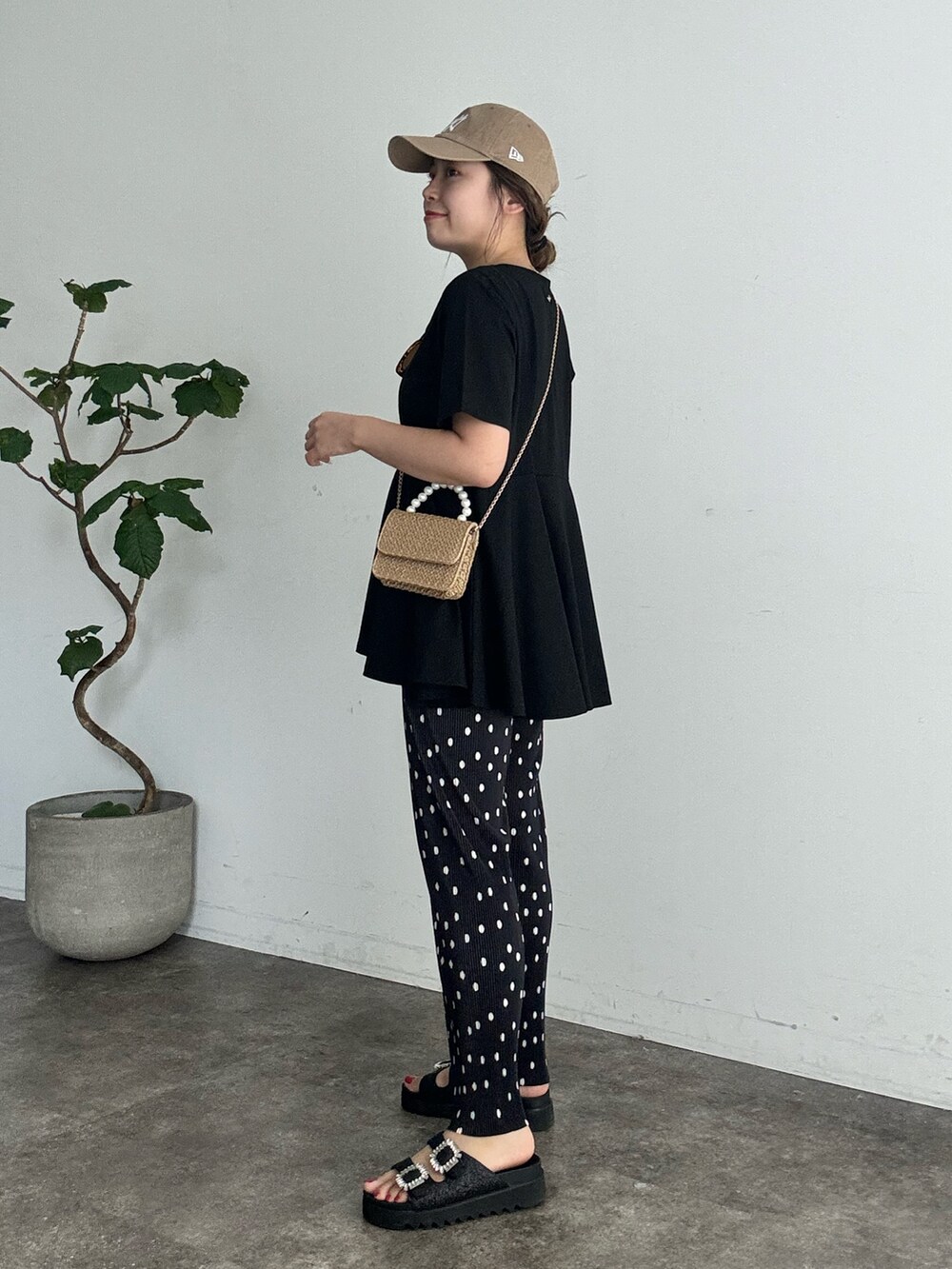 ブラック系のTシャツ/カットソー、ベージュ系のショルダーバッグ、ブラック系のその他パンツを着用したレディースの夏コーディネートの2枚目の写真