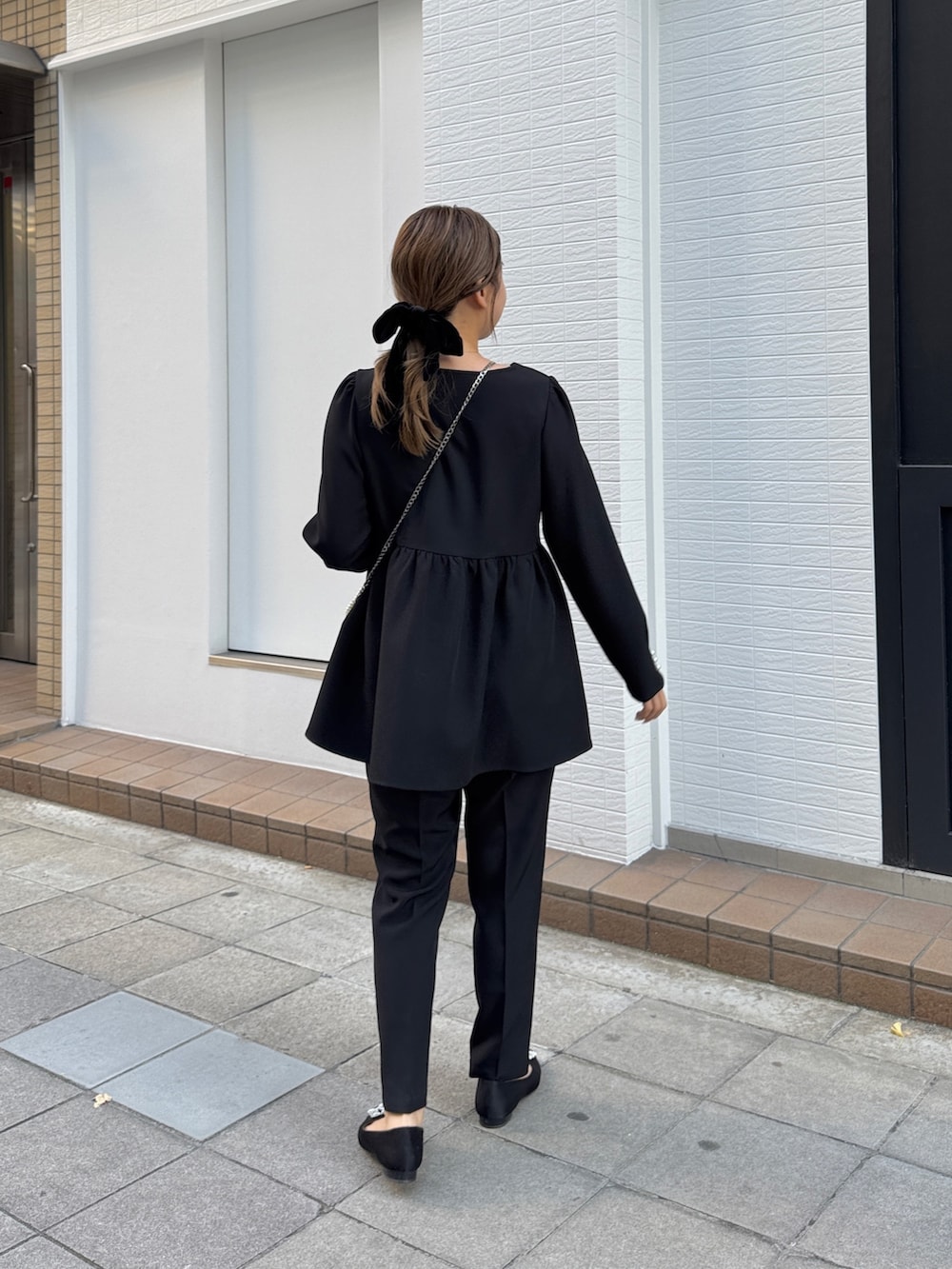 ブラック系のシャツ/ブラウス、ホワイト系のショルダーバッグ、ブラック系のその他パンツを着用したレディースの冬コーディネートの2枚目の写真