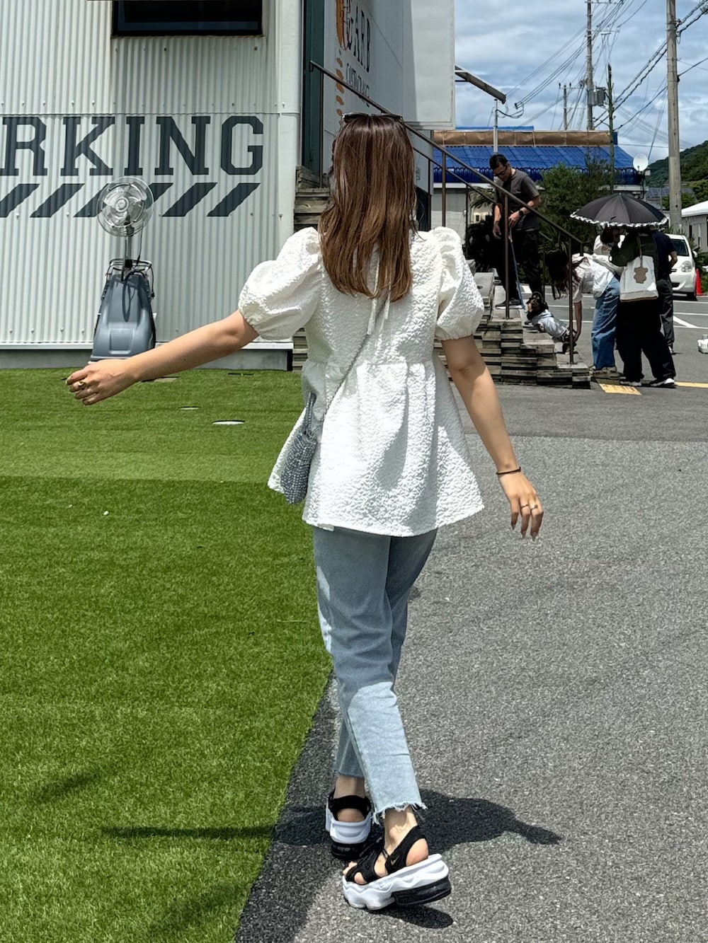 ホワイト系のシャツ/ブラウス、ブルー系のデニムパンツを着用したレディースの夏コーディネートの4枚目の写真