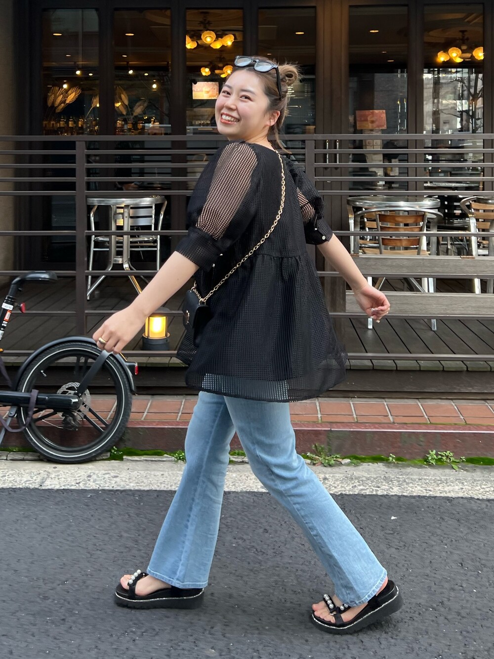 ブラック系のシャツ/ブラウス、ブルー系のデニムパンツ、ブラック系のサンダルを着用したレディースの春コーディネートの3枚目の写真