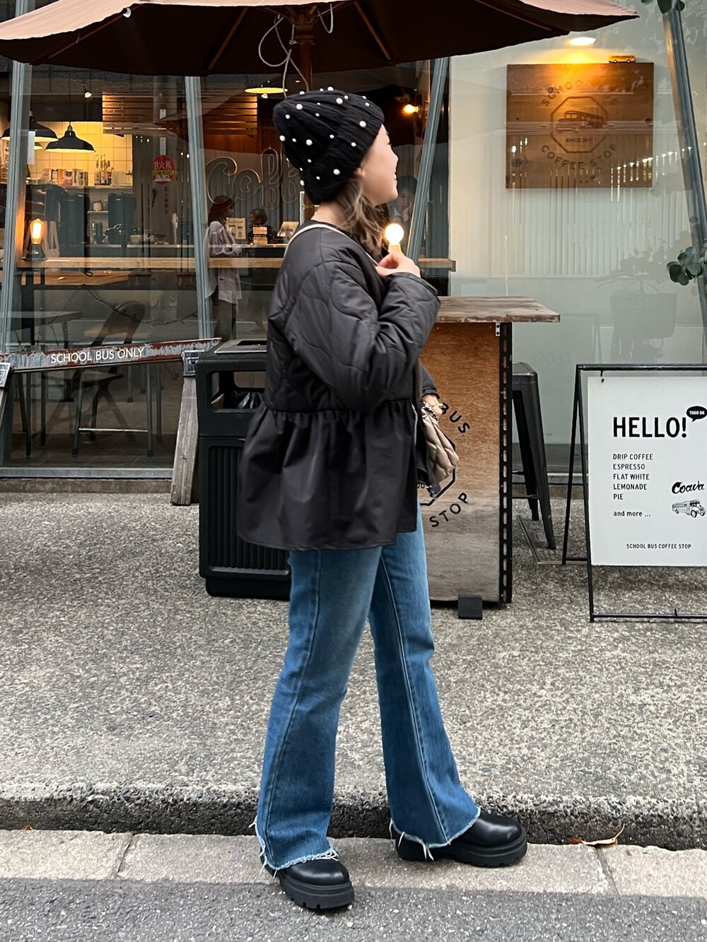 ブラック系のダウンジャケット/コート、ブルー系のデニムパンツ、ブラック系のブーツを着用したレディースの秋コーディネートの3枚目の写真