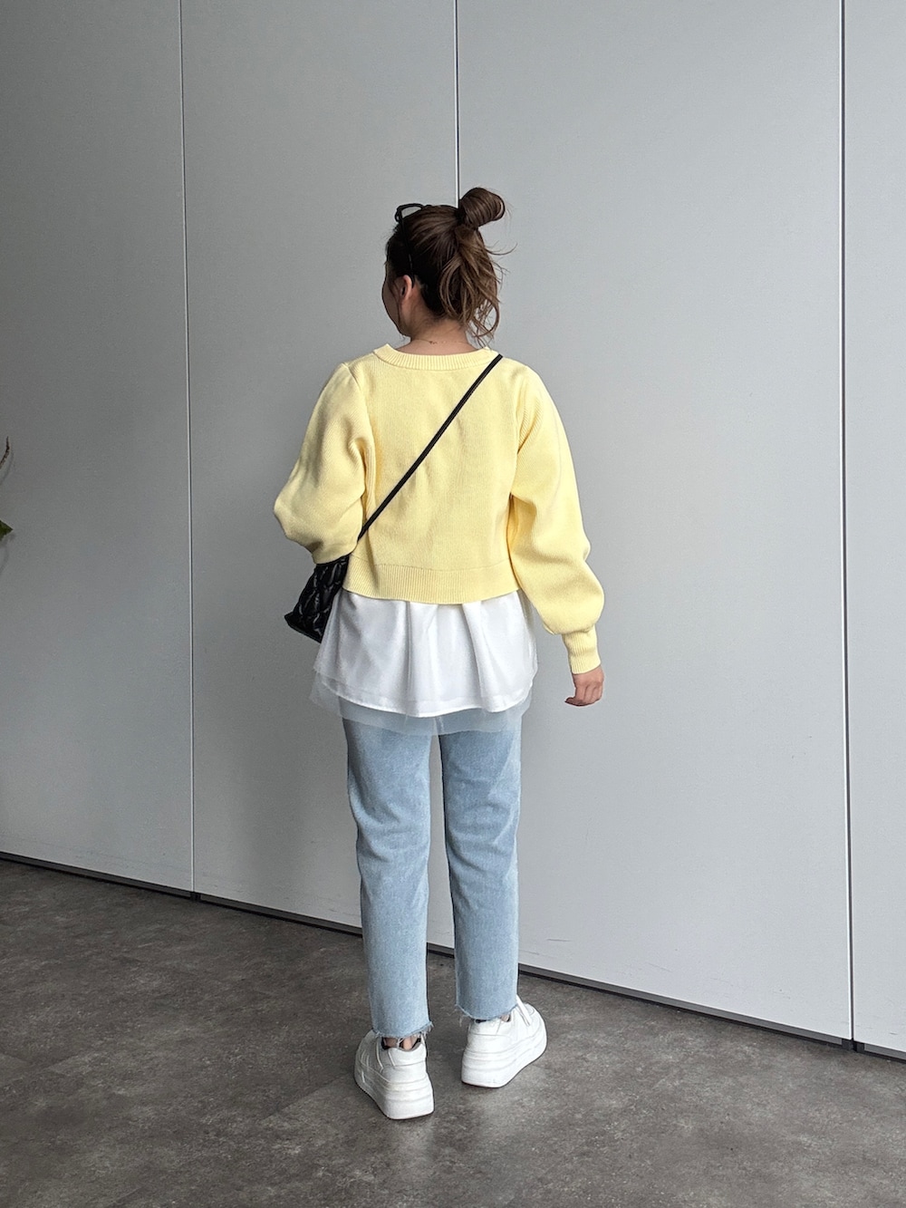 イエロー系のカーディガン/ボレロ、ブラック系のショルダーバッグ、ホワイト系のTシャツ/カットソーを着用したレディースの春コーディネートの3枚目の写真