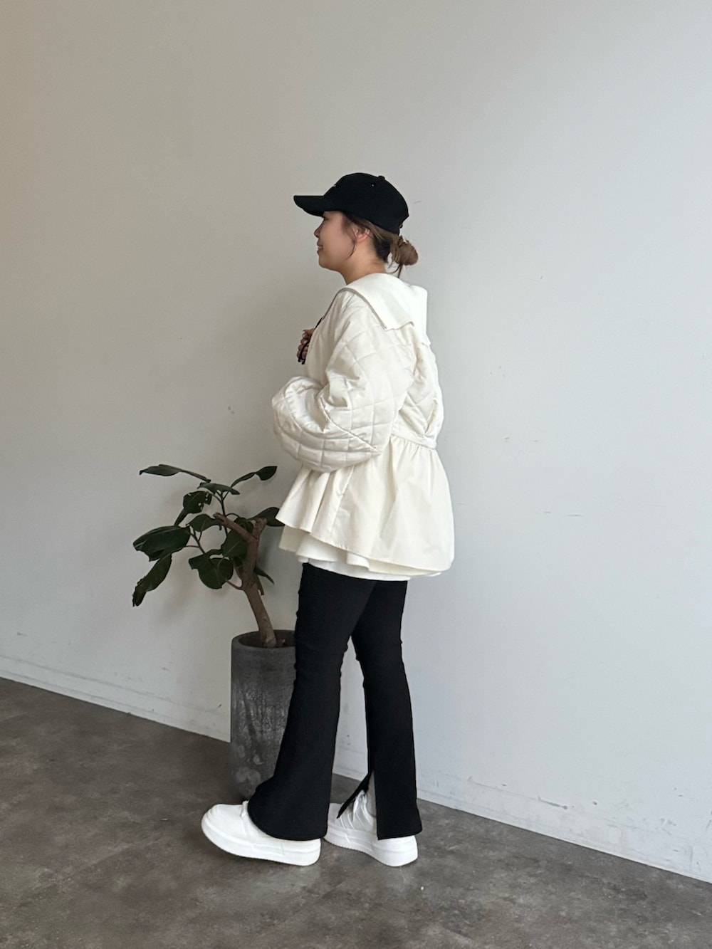 ブラック系のブルゾン、ブラック系のニット/セーター、ホワイト系のTシャツ/カットソーを着用したレディースの冬コーディネートの2枚目の写真