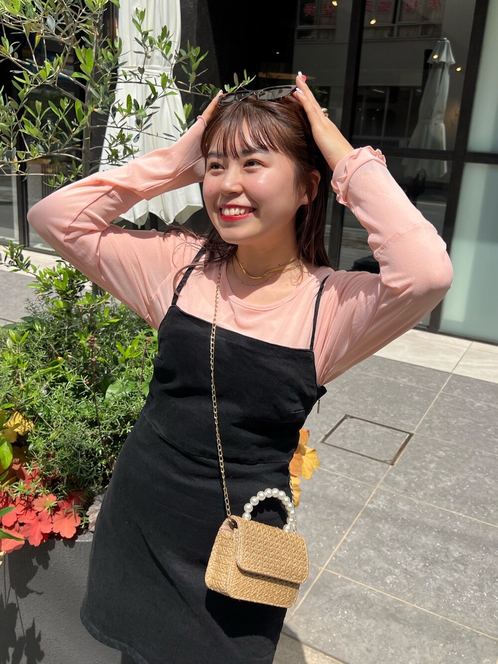 ピンク系のTシャツ/カットソー、ベージュ系のショルダーバッグ、オレンジ系のアイシャドウを着用したレディースの春コーディネートの2枚目の写真