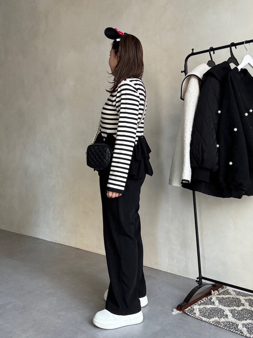 ブラック系のカーディガン/ボレロ、ブラック系のスラックスを着用したレディースの秋コーディネートの2枚目の写真