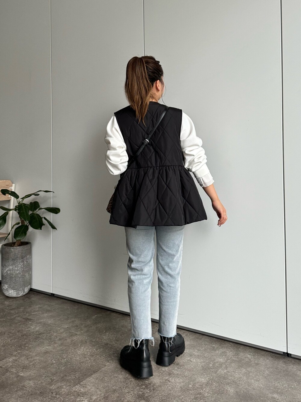 ブラック系のベスト、ホワイト系のTシャツ/カットソー、ブラウン系のバッグを着用したレディースの秋コーディネートの3枚目の写真