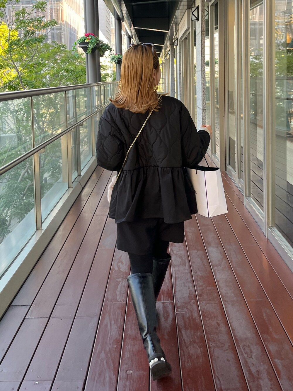 ベージュ系のニット/セーター、ブラック系のダウンジャケット/コート、ブラウン系のショルダーバッグを着用したレディースの秋コーディネートの5枚目の写真