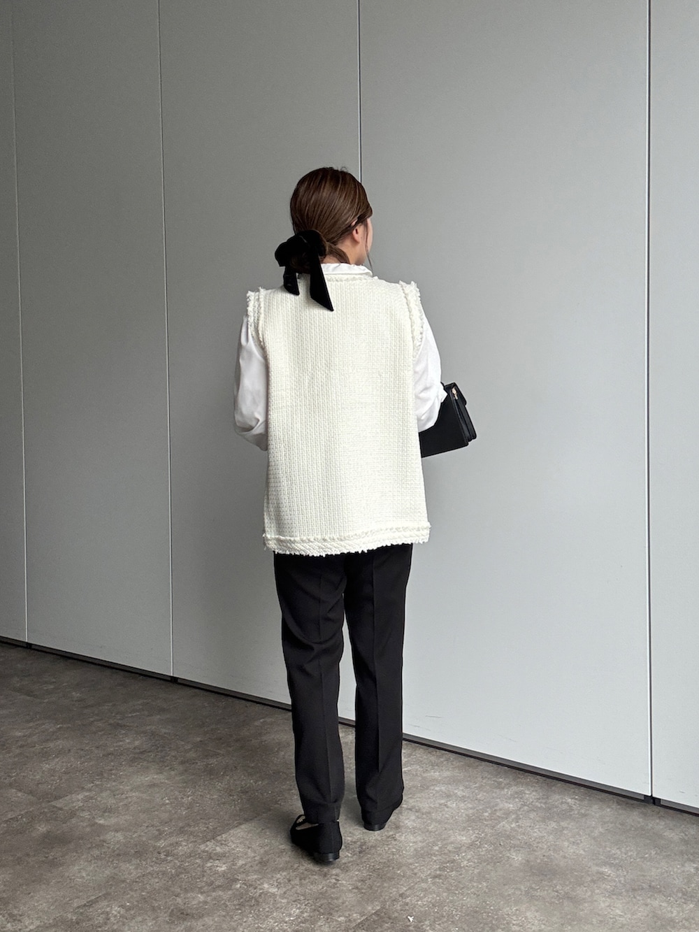 ホワイト系のシャツ/ブラウス、ホワイト系のベスト、ブラック系のスラックスを着用したレディースの春コーディネートの2枚目の写真