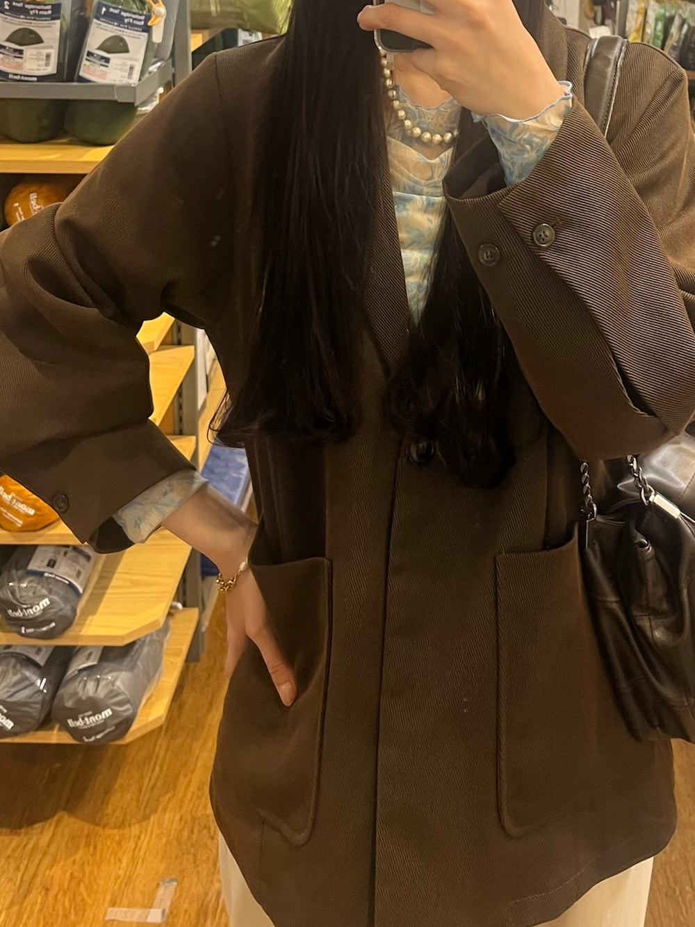 ブラック系のスラックス、ブラウン系のテーラードジャケット、ブルー系のTシャツ/カットソーを着用したレディースの春コーディネートの2枚目の写真