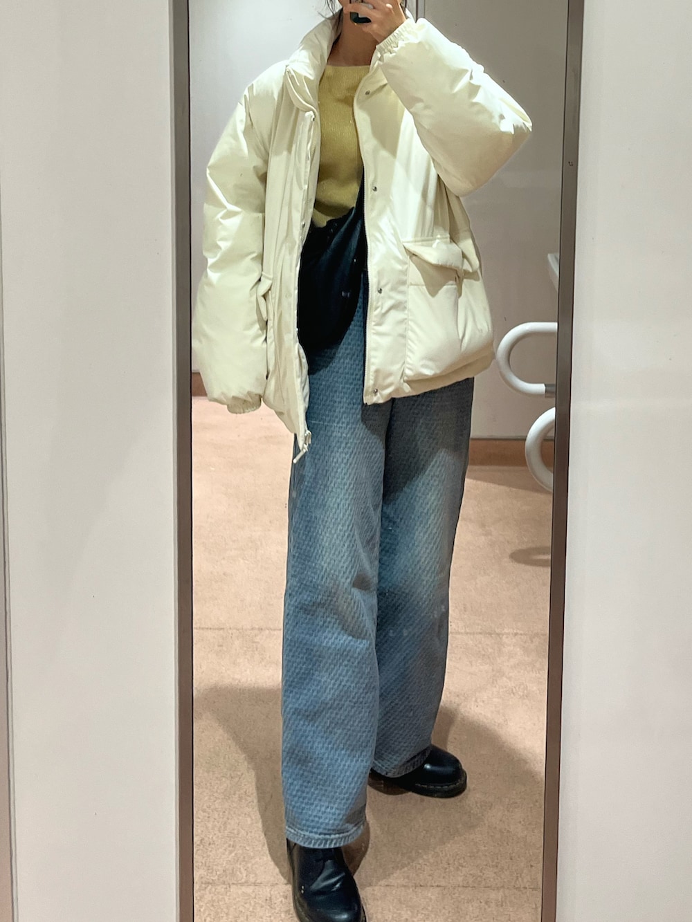 ホワイト系のダウンジャケット/コート、ブラック系のショルダーバッグ、イエロー系のニット/セーターを着用したレディースの冬コーディネートの2枚目の写真