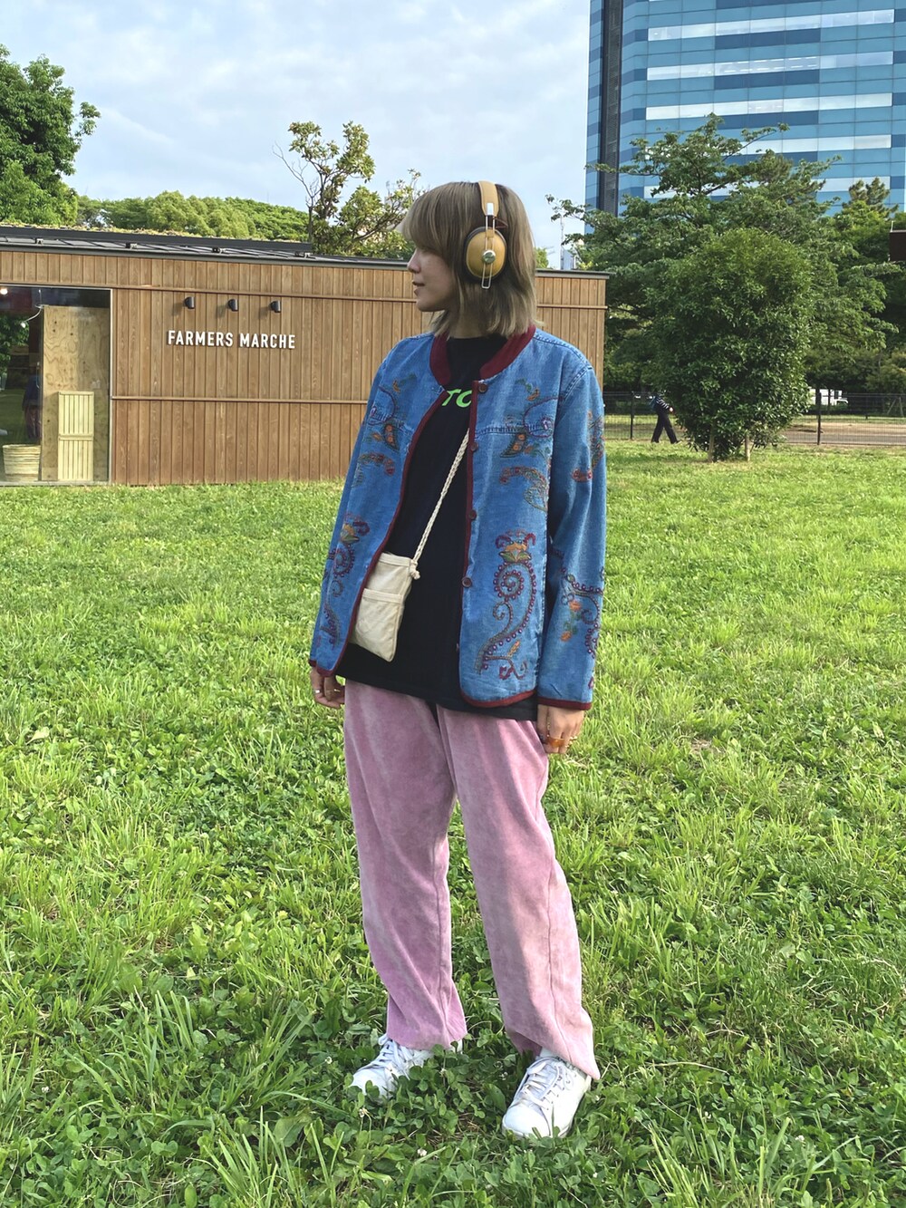 ブラック系のTシャツ/カットソー、ベージュ系のバッグ、ブルー系のデニムジャケットを着用したレディースの春コーディネートの2枚目の写真
