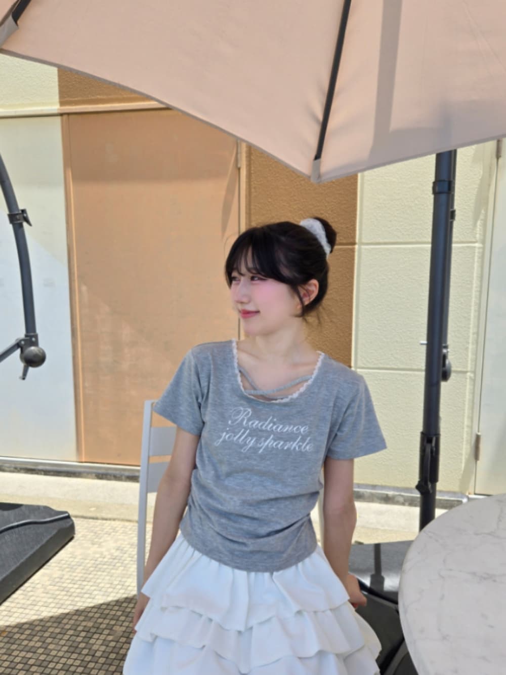 グレー系のTシャツ/カットソー、ホワイト系のスカートを着用したレディースの夏コーディネートの2枚目の写真