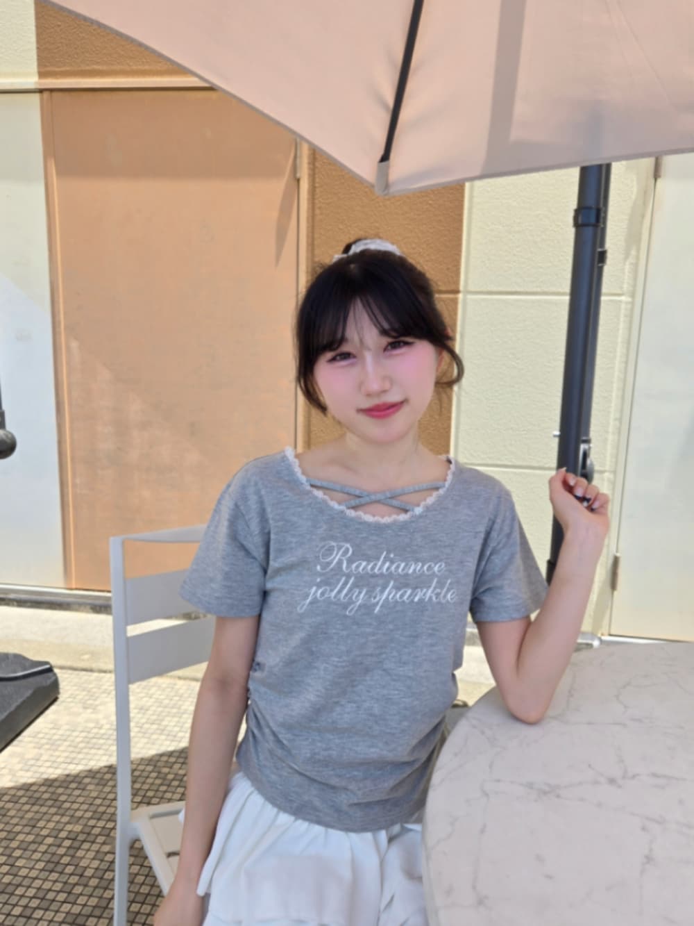 グレー系のTシャツ/カットソー、ホワイト系のスカートを着用したレディースの夏コーディネートの4枚目の写真