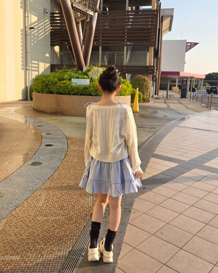 ブルー系のワンピース、ホワイト系のカーディガン/ボレロを着用したレディースの春コーディネートの2枚目の写真