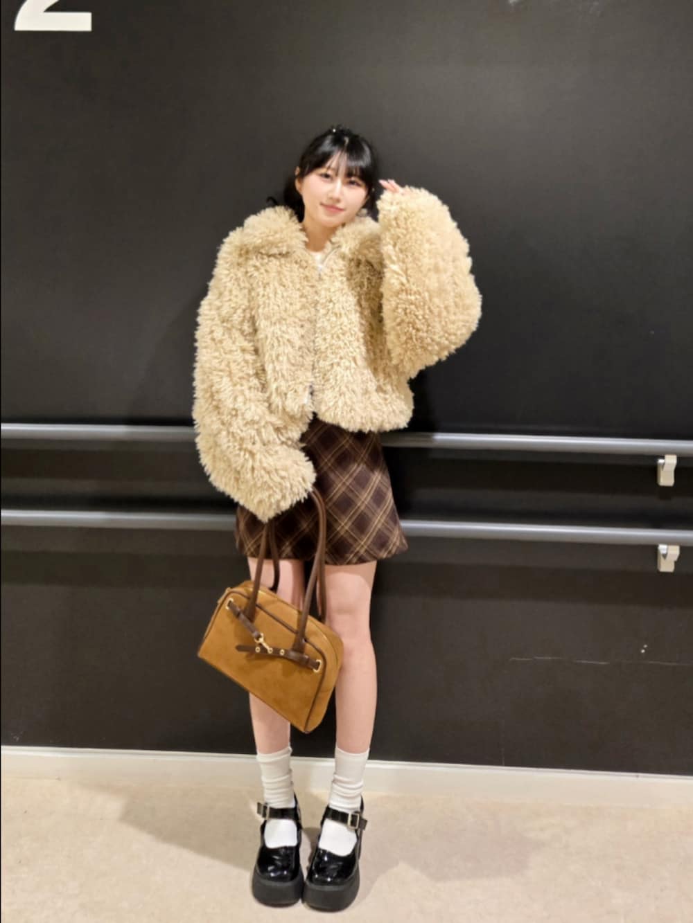 ベージュ系のブルゾン、ブラウン系のスカート、イエロー系のハンドバッグを着用したレディースの冬コーディネートの3枚目の写真