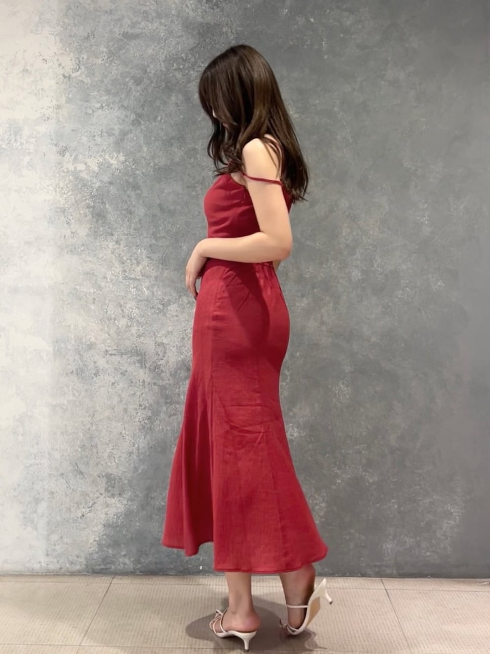 レッド系のワンピース、ホワイト系のサンダルを着用したレディースの夏コーディネートの3枚目の写真