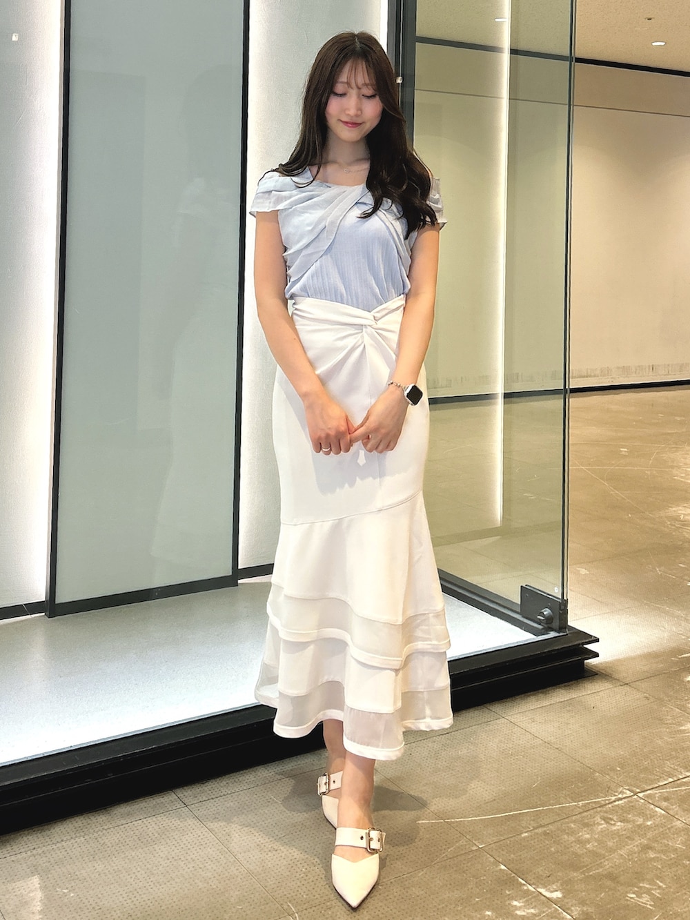 ホワイト系のスカート、ブルー系のTシャツ/カットソーを着用したレディースの春コーディネートの6枚目の写真