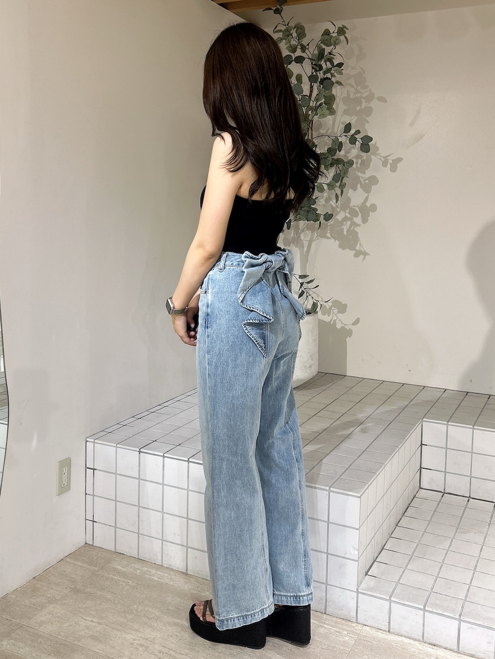 ブルー系のデニムパンツ、ブラック系のキャミソール、ブラック系のサンダルを着用したレディースの夏コーディネートの2枚目の写真