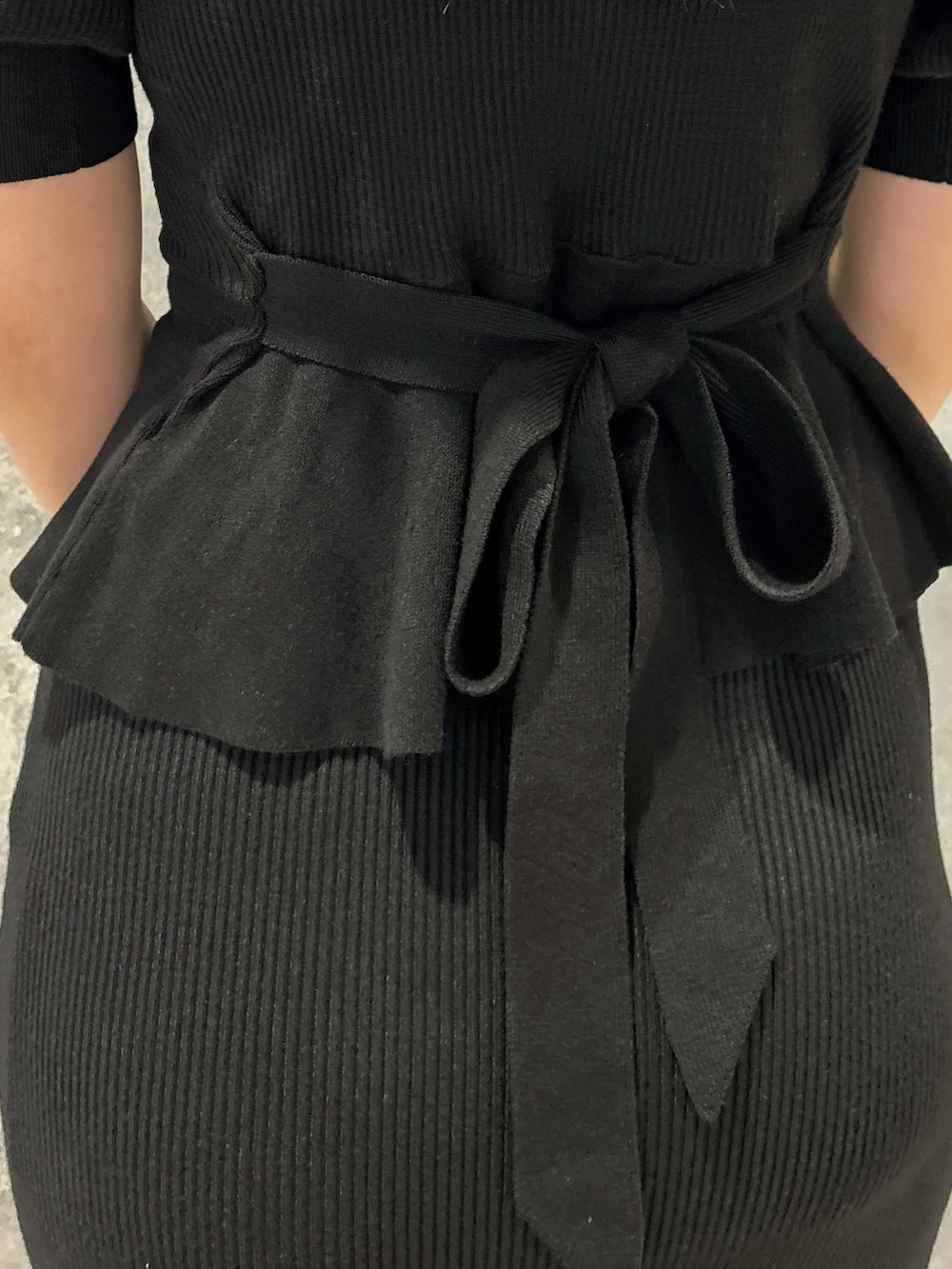 ブラック系のスカート、ブラック系のニット/セーター、ブラック系のハンドバッグを着用したレディースの春コーディネートの4枚目の写真