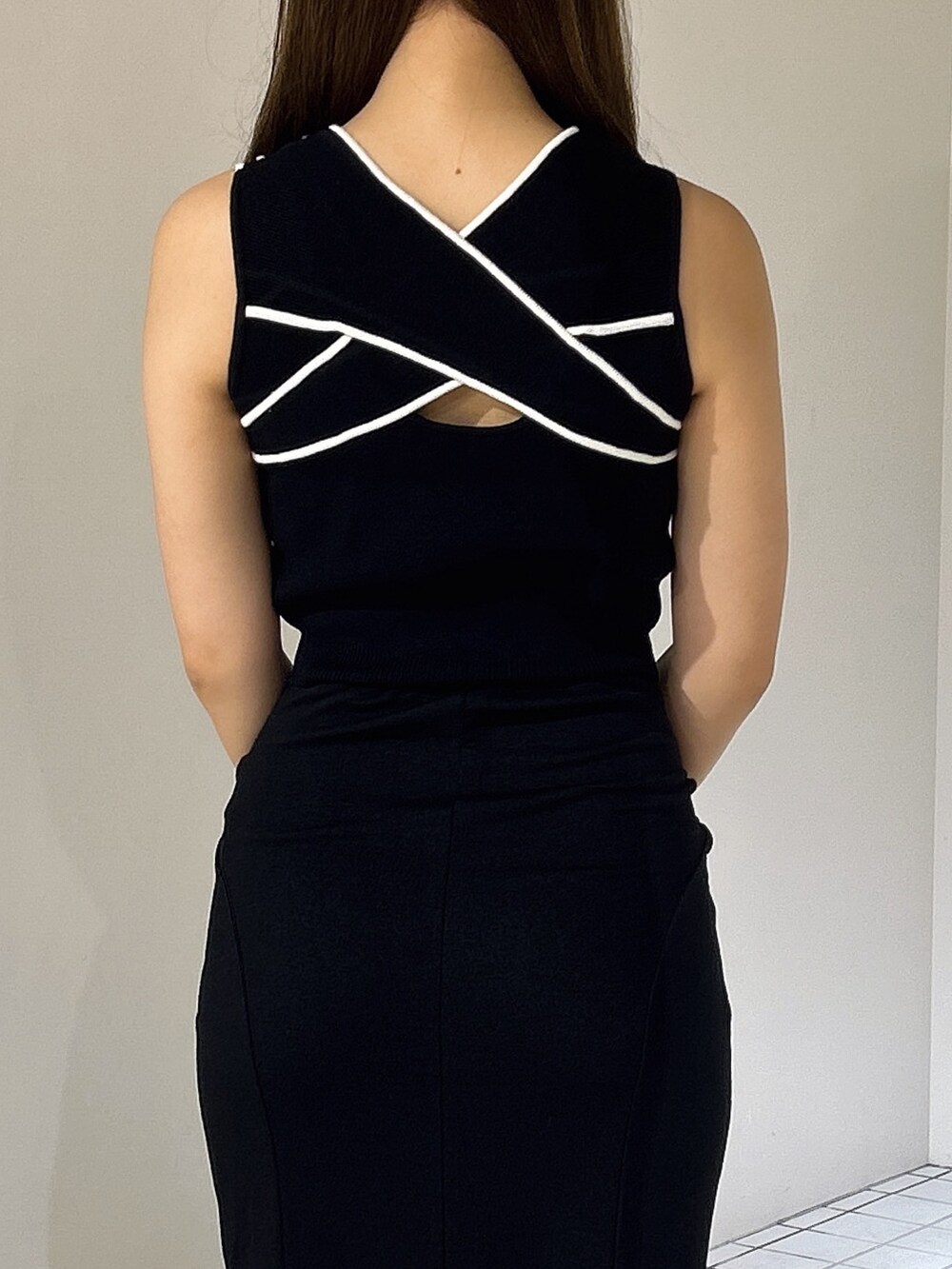 ブラック系のスカート、ホワイト系のサンダル、ブラック系のタンクトップを着用したレディースの夏コーディネートの4枚目の写真