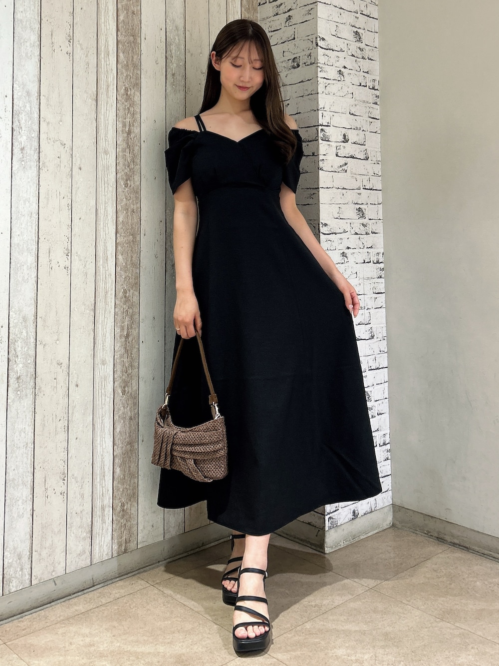 ブラック系のワンピース、ブラウン系のハンドバッグを着用したレディースの夏コーディネートの6枚目の写真