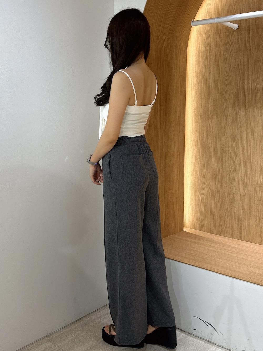 グレー系のスウェットパンツ、ホワイト系のキャミソール、ブラック系のサンダルを着用したレディースの夏コーディネートの4枚目の写真