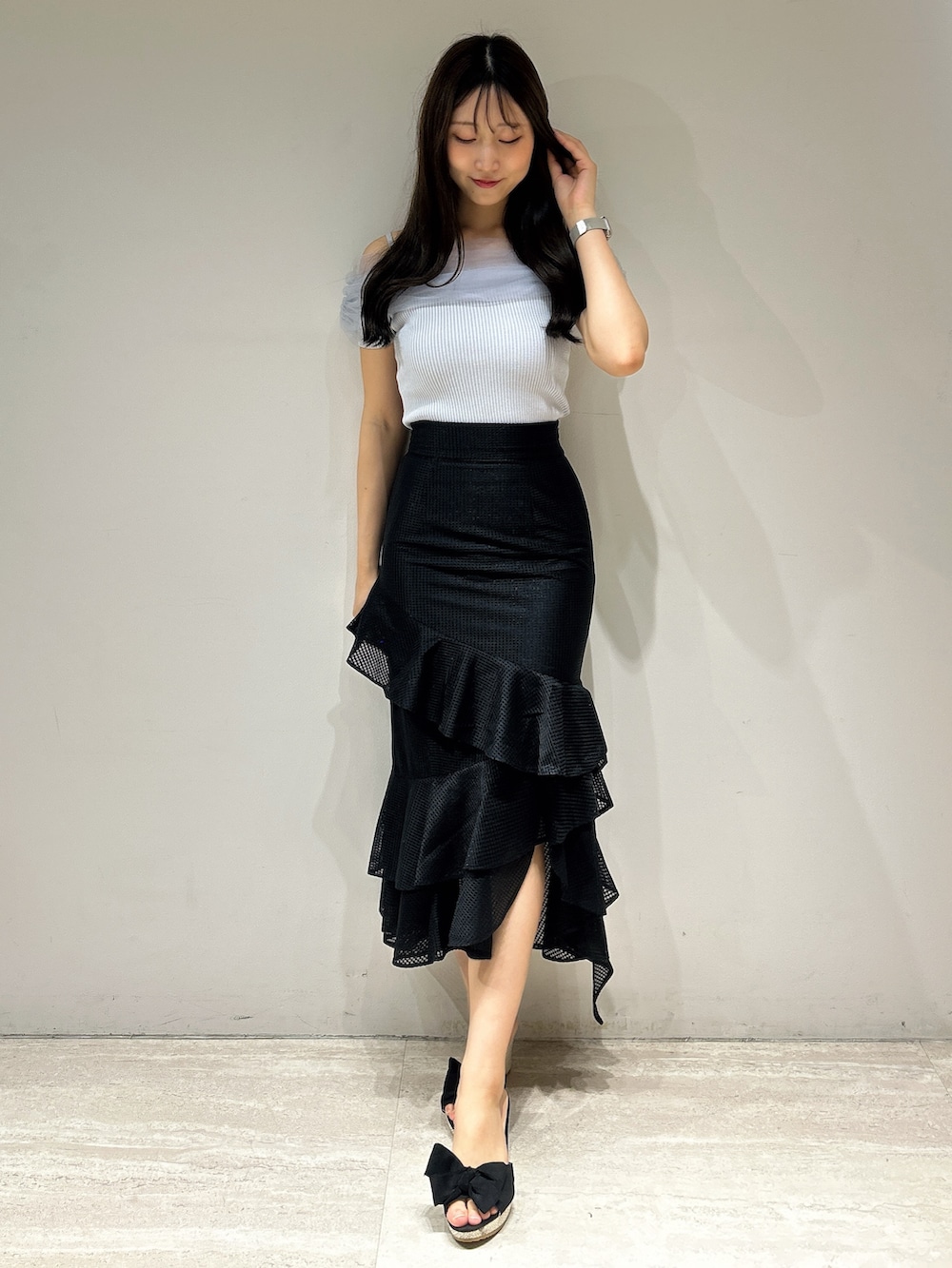 ブラック系のスカート、ブルー系のニット/セーターを着用したレディースの夏コーディネートの2枚目の写真