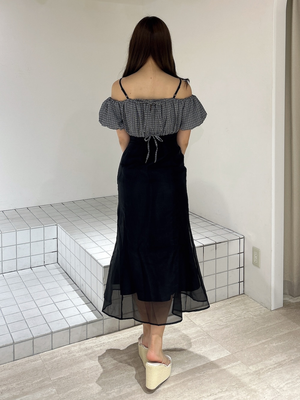 ブラック系のワンピース、ホワイト系のサンダルを着用したレディースの夏コーディネートの4枚目の写真