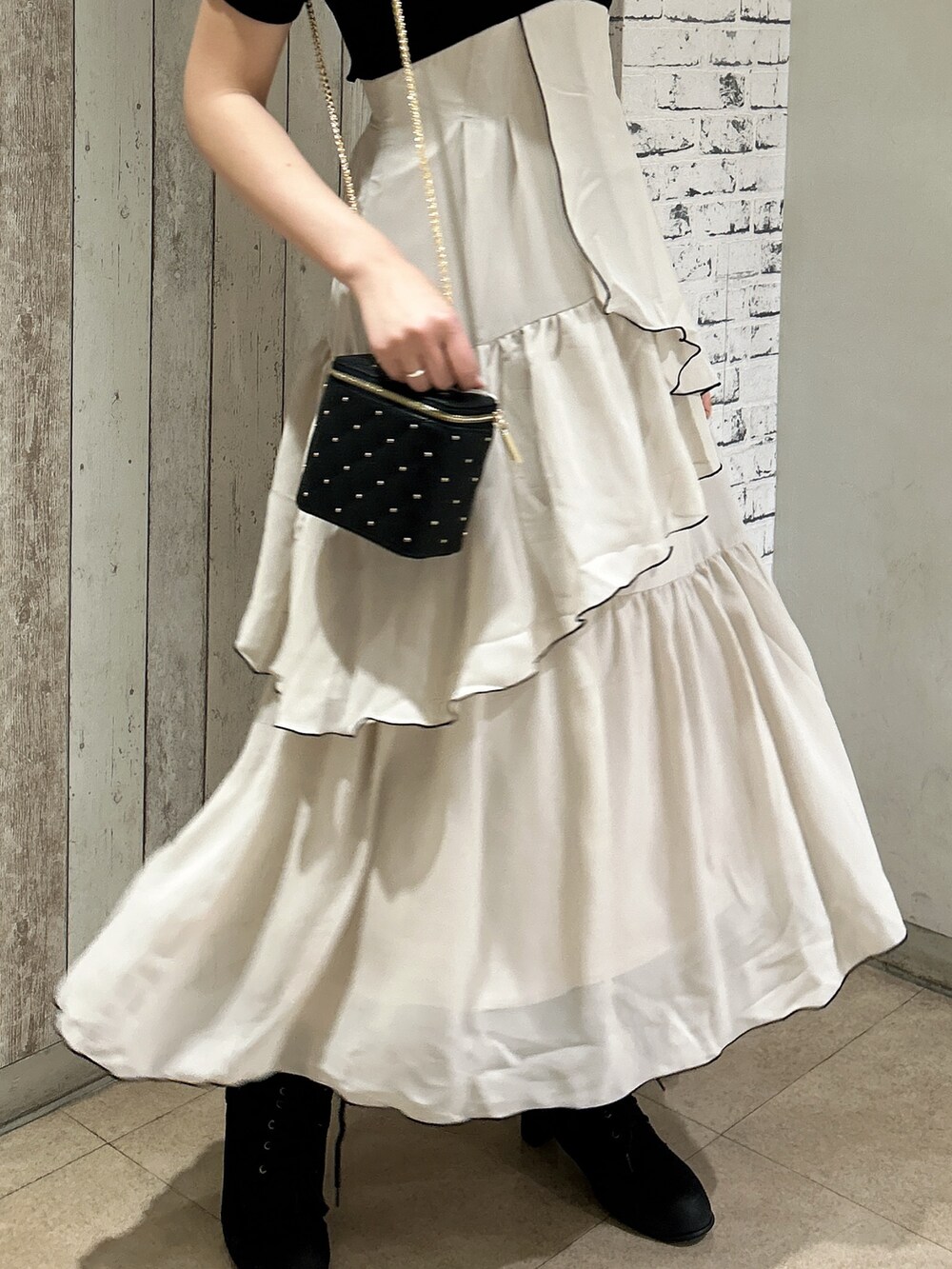 ブラック系のワンピース、ブラック系のショルダーバッグを着用したレディースの春コーディネートの6枚目の写真